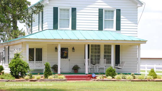 Country farmhouse with a shed roof design over wrap around porch