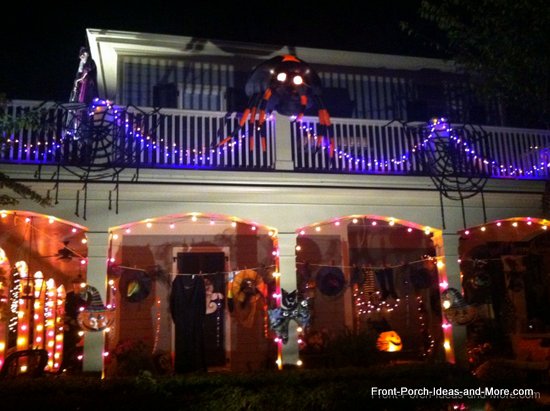 they have window decorations that are back lighted and a creepy spider crawling up the wall outdoor halloween