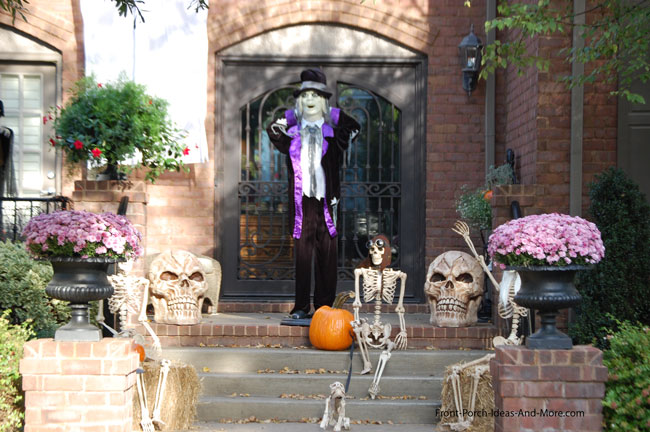 scarecrow and pumpkins on porch steps