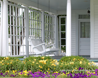 white porch swing on landscaped front porch