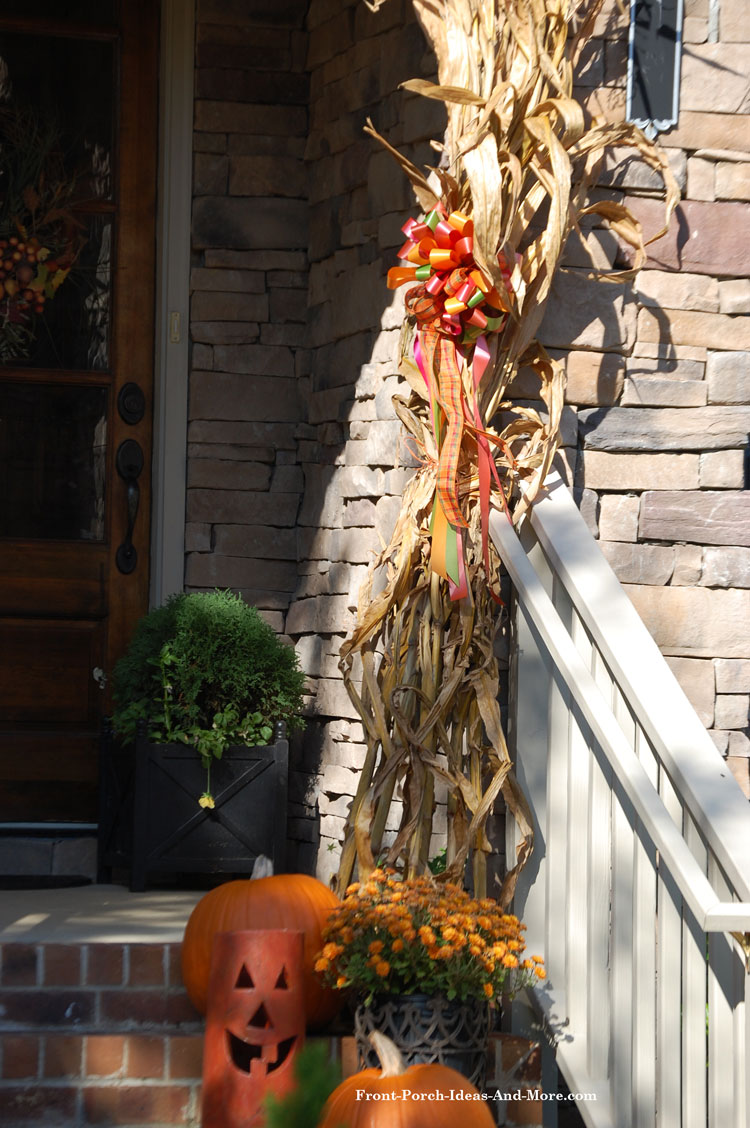 corn stalks for fall on front porch tied with ribbon