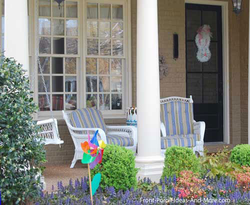 wicker furniture with colorful cushions on front porch