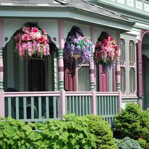 hanging baskets full of colorful flowers on front porch