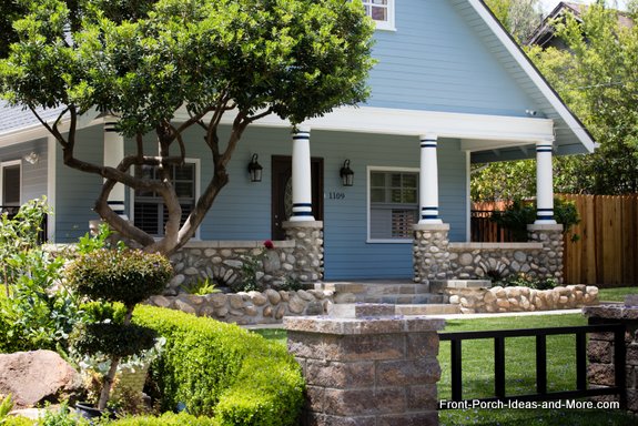 white round tapered porch columns with blue trim and stone balustrade