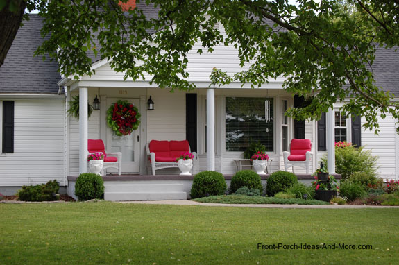 Classic white front porch with red pillows