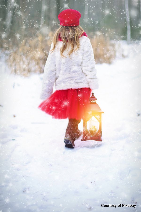 young girl walking in snow with lantern