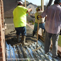 men working concrete for flooring on elevated front porch