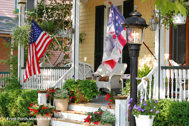 front porch with American Flag and colorful flower pots