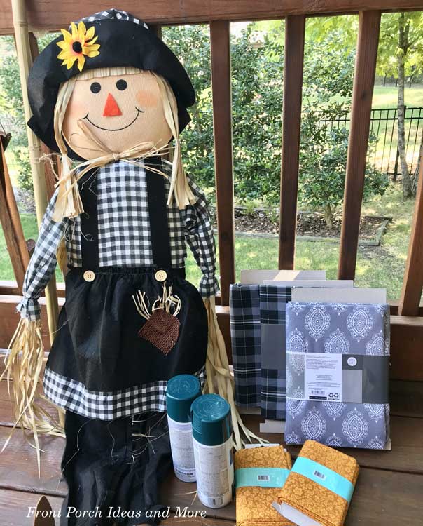 black and white scarecrow and other materials to decorate porch