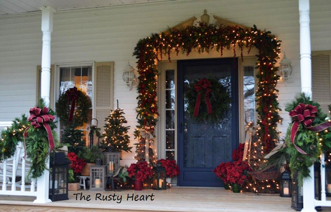 front door decorated for Christmas with garland by the rusty heart