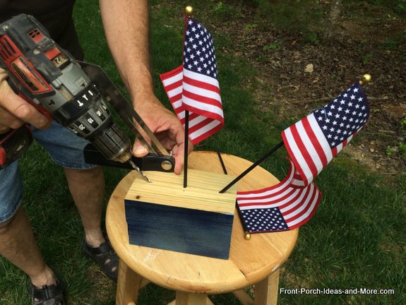 Drilling holes for our flags onto our Memorial Day Tribute Project