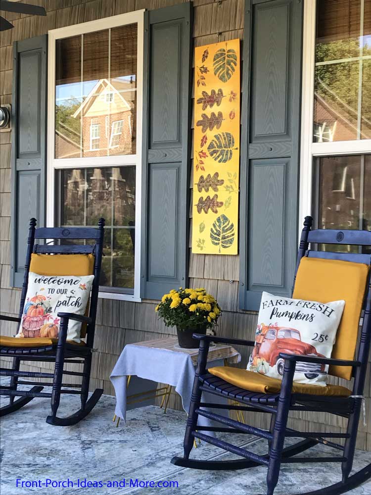 our autumn porch has golden cushion covers and fun pillow covers