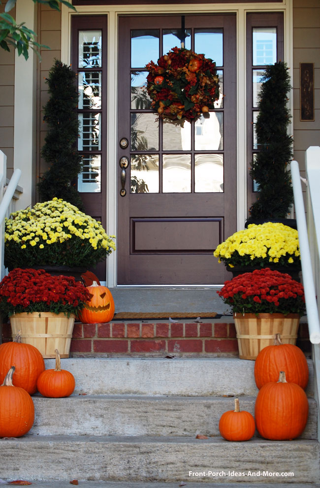 pumpkins and mums lining the front porch steps