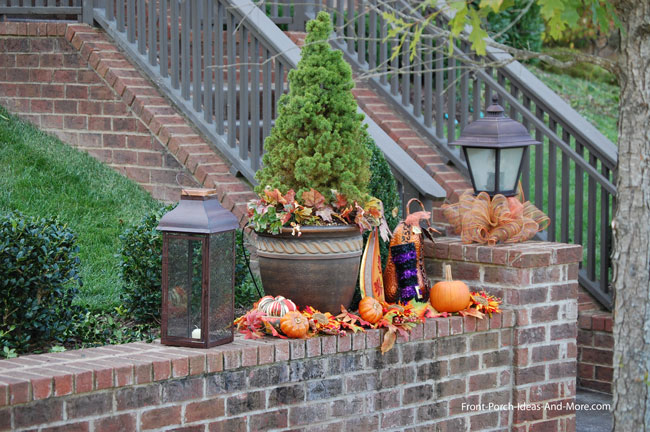 fall decorations on retaining wall to front porch