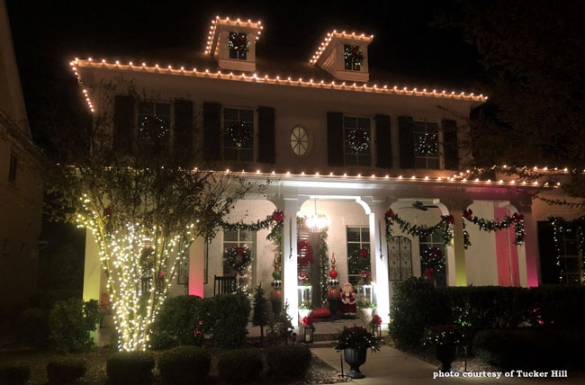 front of home and porch illuminated with Christmas lights