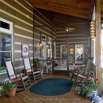 log home with amazing front porch with furniture