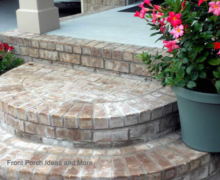 round brick porch steps with pot of flowers
