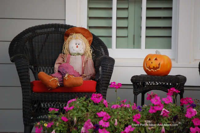 raggedy ann or andy with pumpkin on front porch for fall