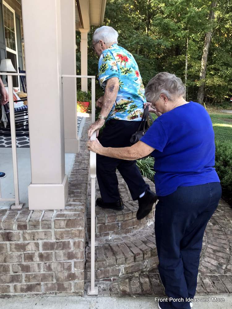 man and woman holding onto porch hand rails