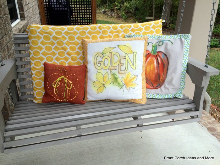 front porch swing with autumn pillows